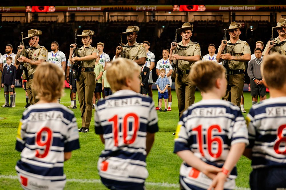 Young players watch Anzac Day memorial game ceremony captured by sports photographer at suncorp stadium