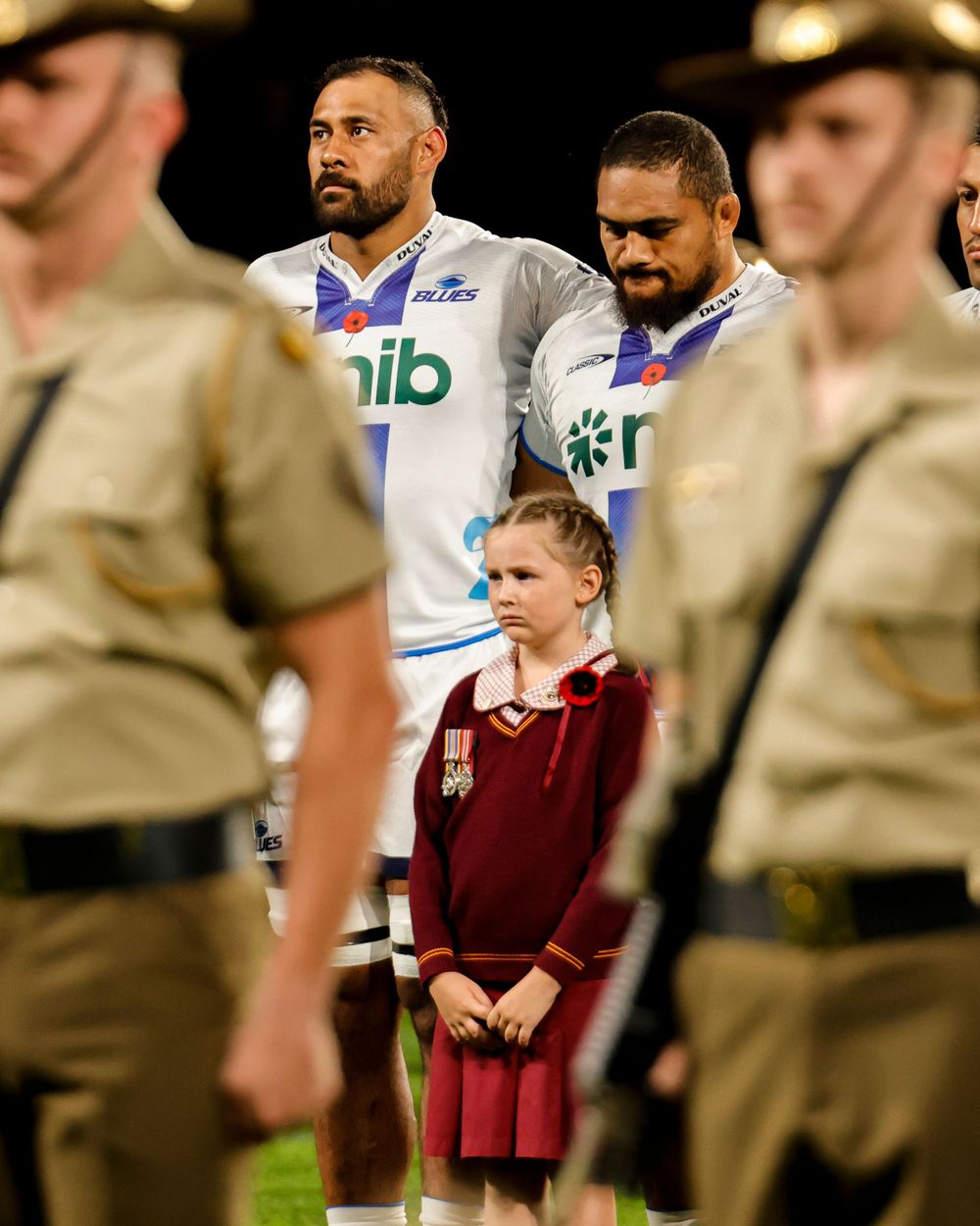 young girl participates in Anzac Day memorial game ceremony captured by sports photographer at suncorp stadium
