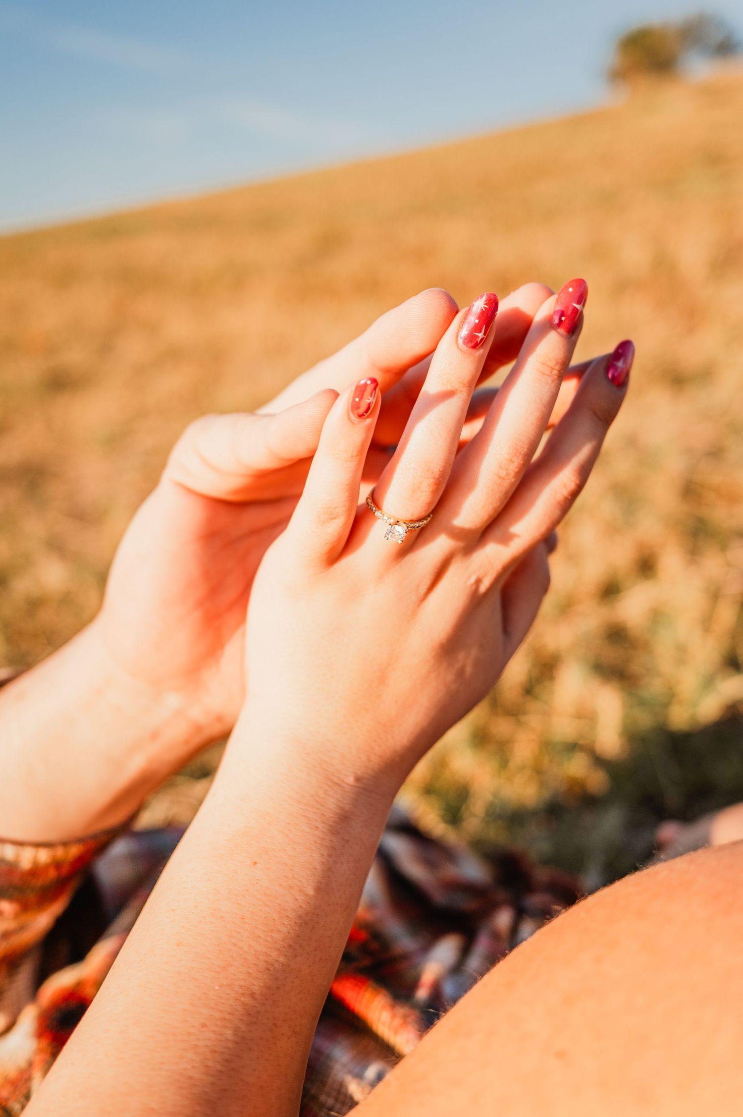 Bare feet with painted toenails basking in warm sunlight against a golden hillside background.