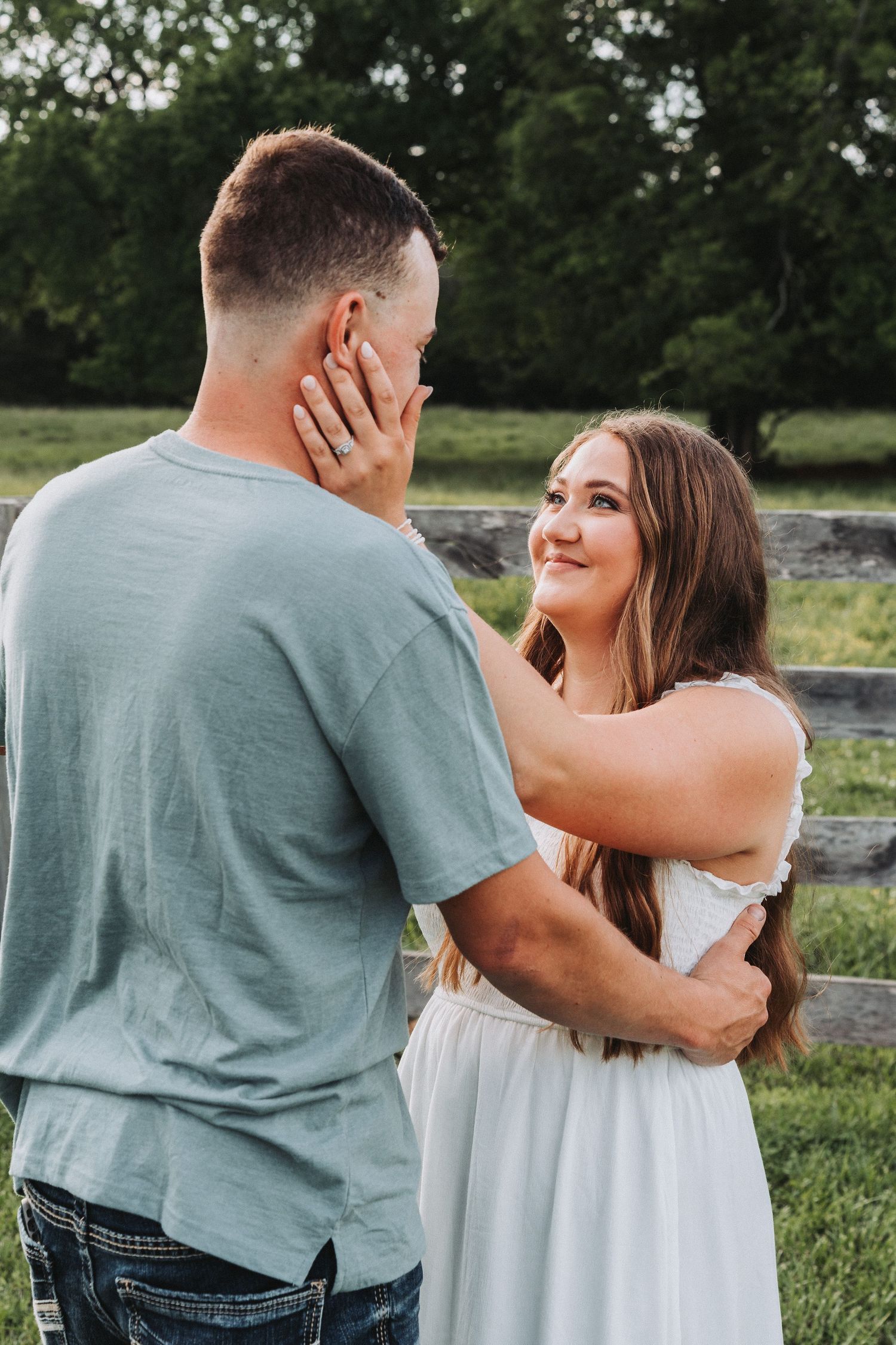 Intimate moment captured between couple in casual attire outdoors.