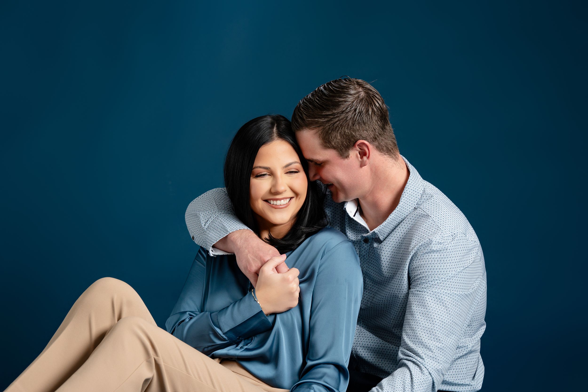 Intimate couple portrait against blue background showing tender moment. branding North Platte Nebraska Photographer