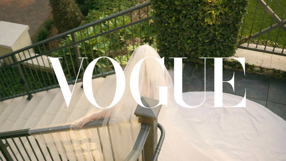 Elegant outdoor wedding venue with ivy-covered walls and Vogue magazine branding.