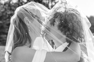 A series of black and white photos shows a couple kissing and embracing during a romantic wedding photoshoot.