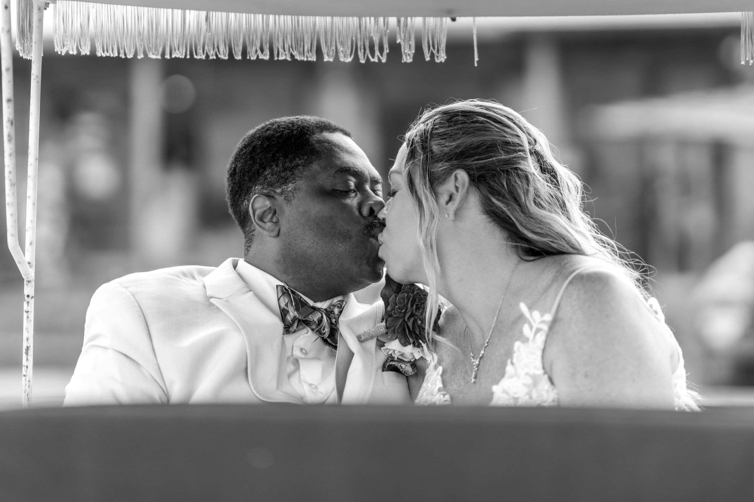 Two people share an intimate moment on a dance floor beneath warm lighting and romantic decor.