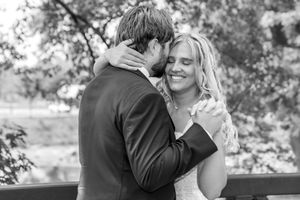 A couple embraces and smiles during an intimate outdoor black and white photo session.