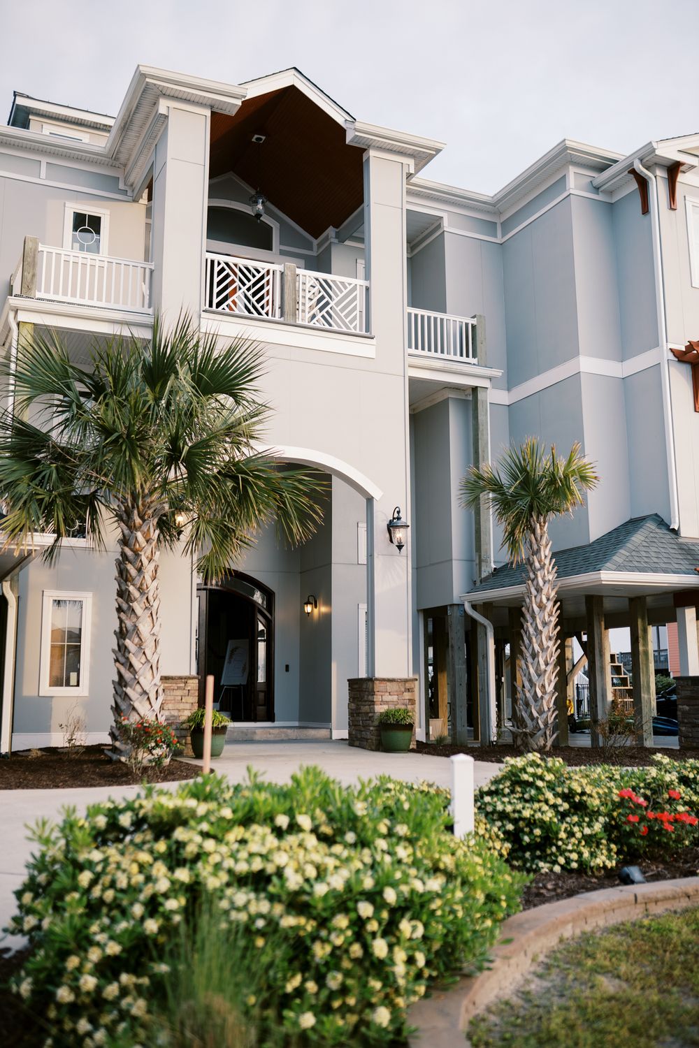 Elegant coastal wedding venue with palm trees and white architectural details.