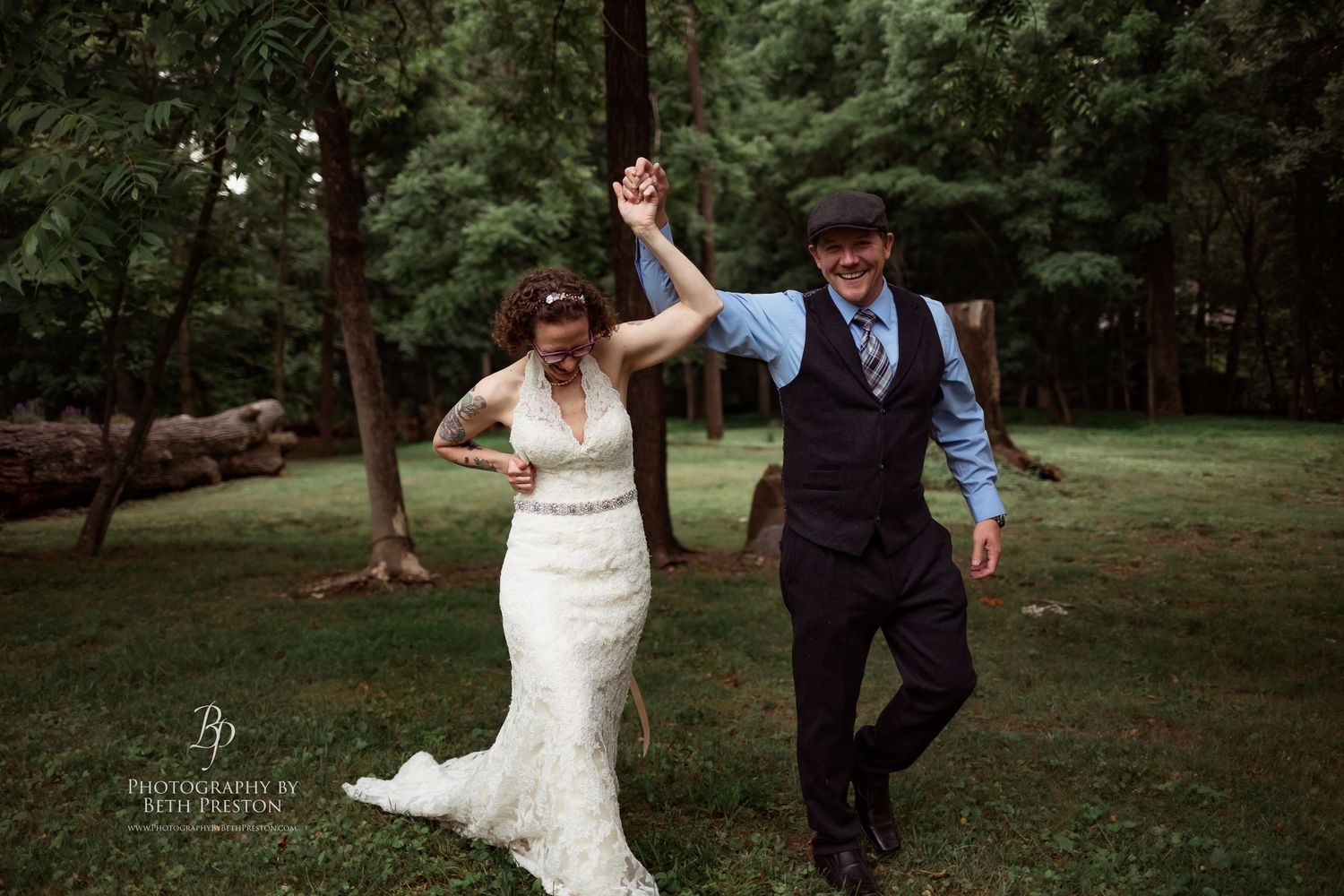Joyful couple celebrates during their forest wedding reception.