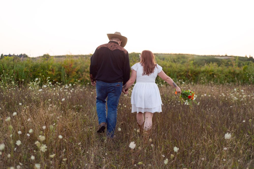 Six photos show a couple walking through a wildflower meadow at sunset in matching casual outfits.