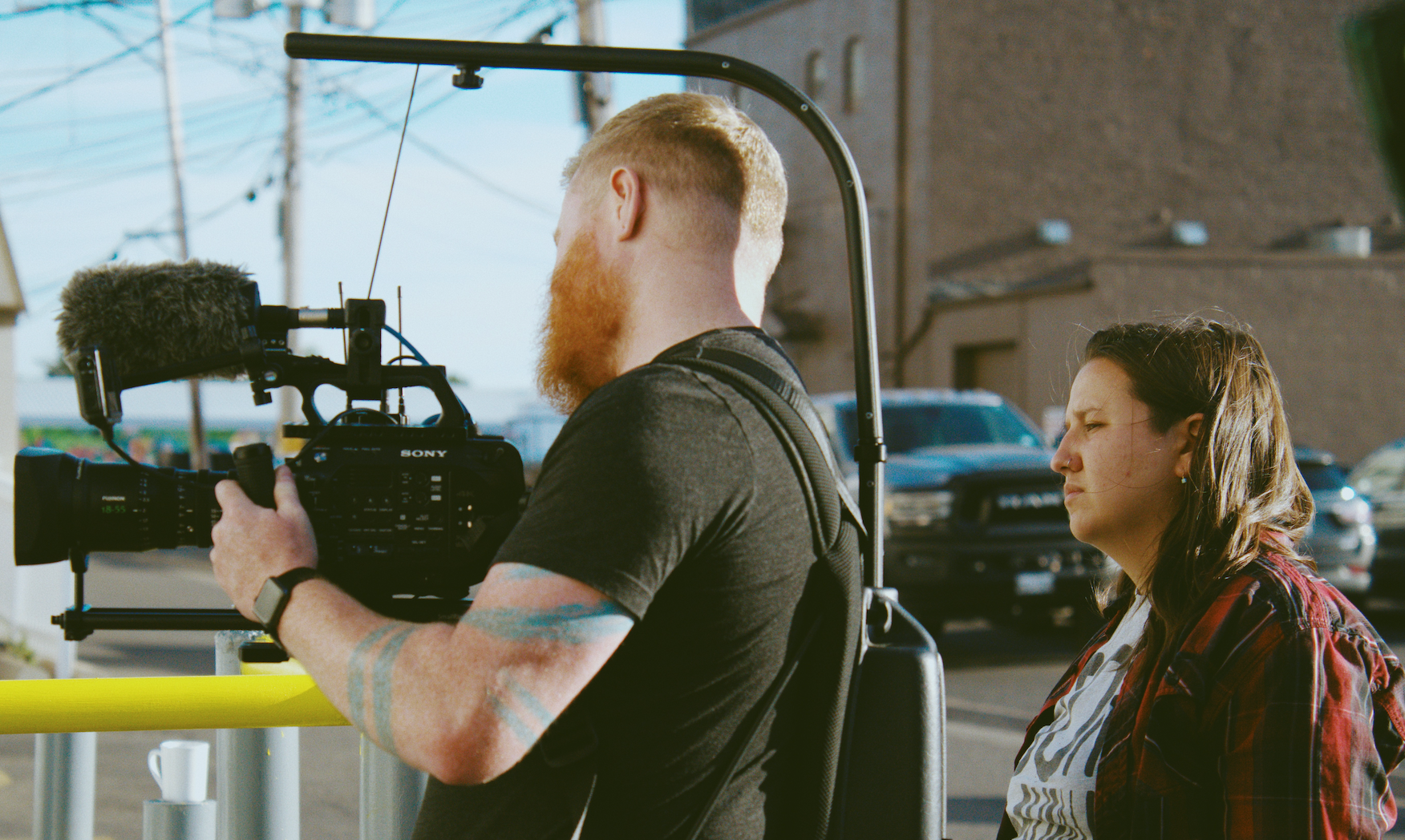 Camera operator filming with professional equipment in studio setting.
