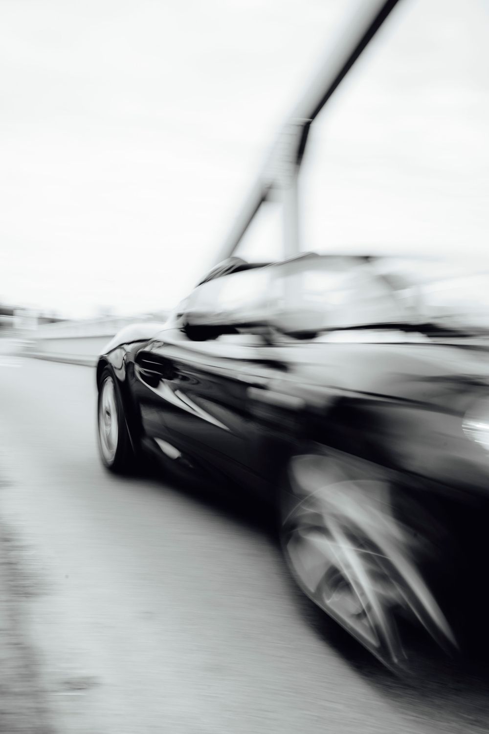 Abstract motion blur photograph of a sleek black sports car.