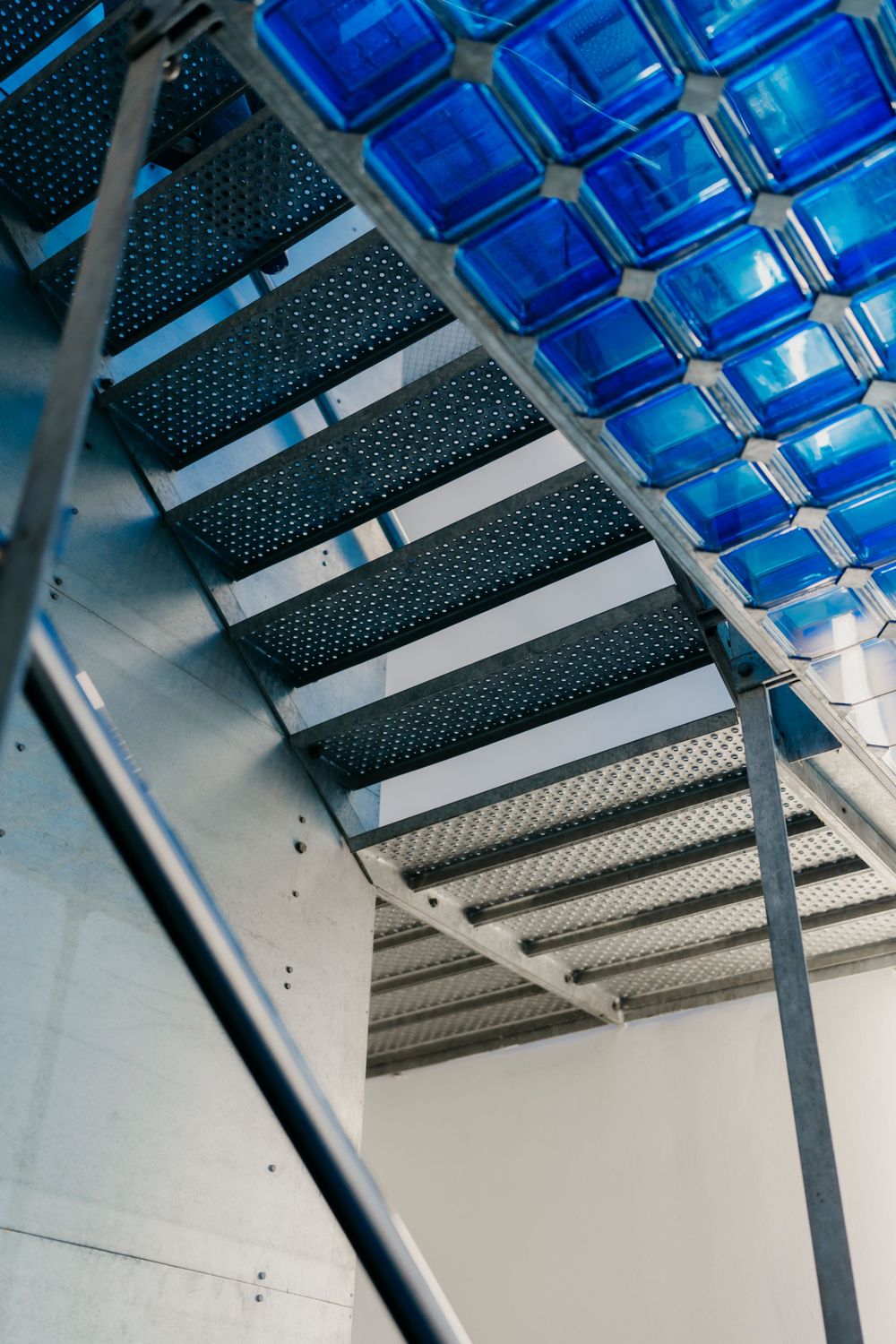 Architectural detail showing blue glass panels and metal framework in modern structure.