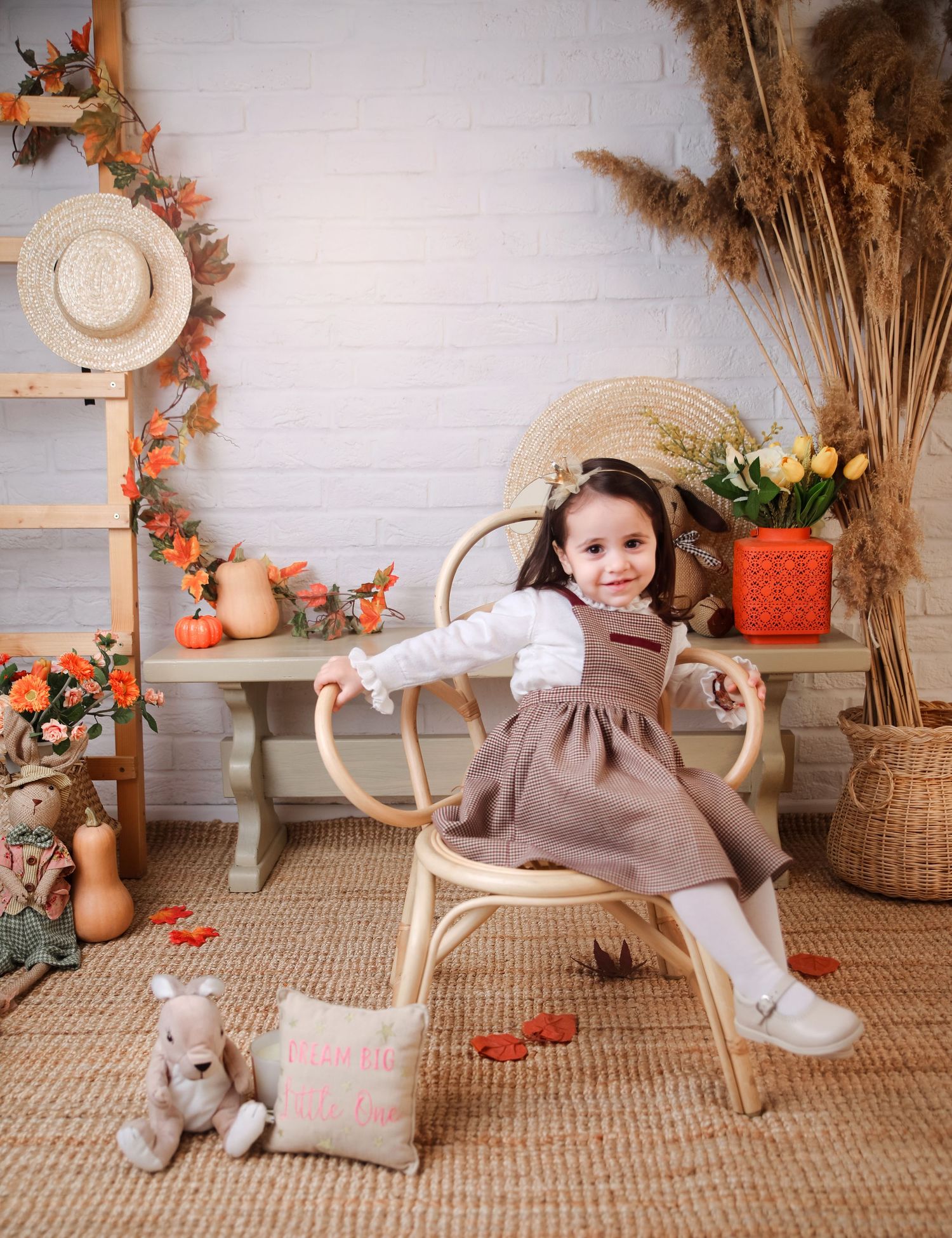 Fall-themed indoor portrait setup with rustic decorations and pumpkin accents.