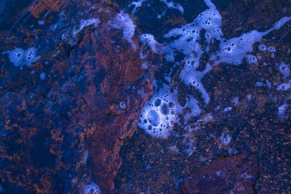 Abstract aerial view showing blue and orange patterns in natural terrain.