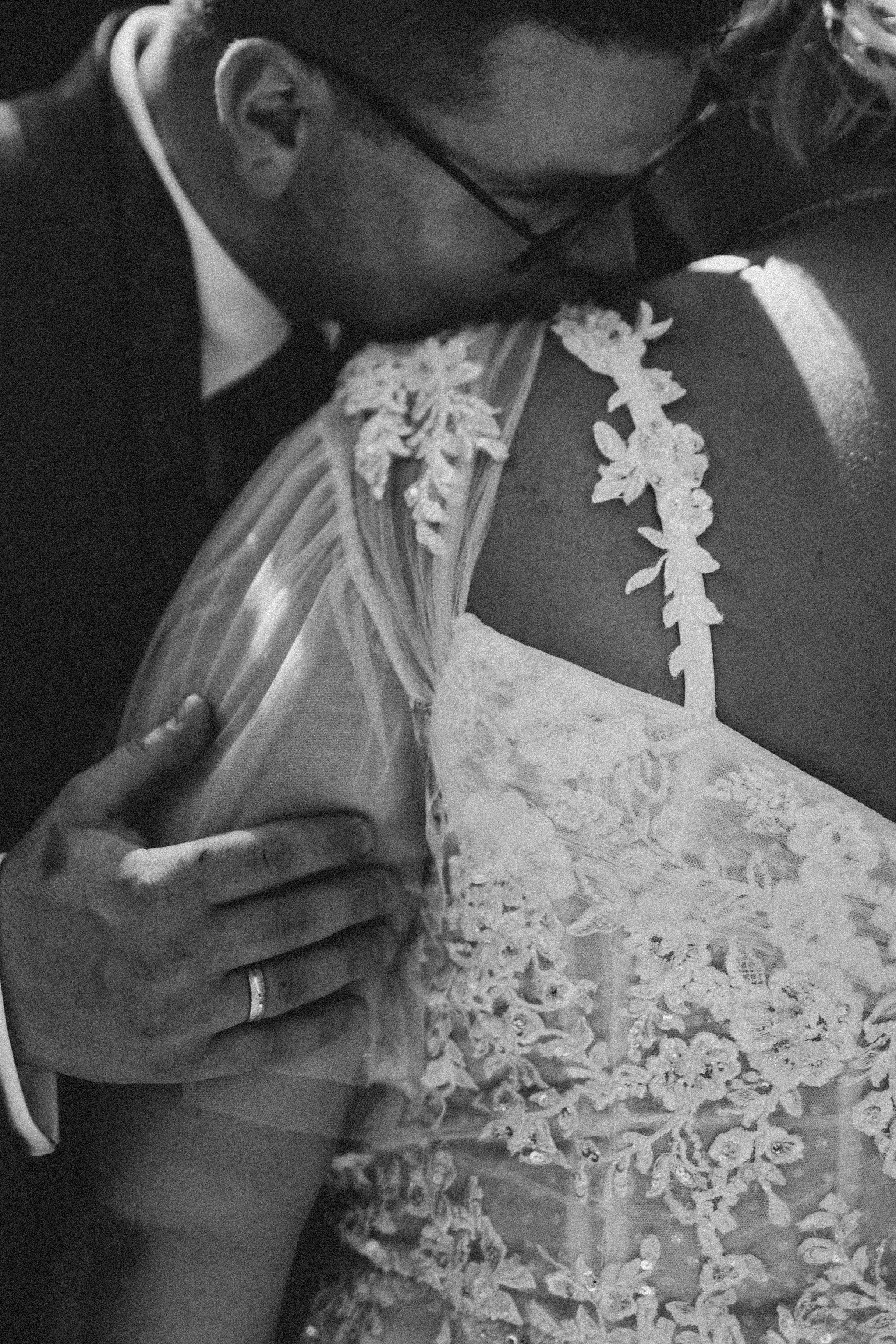 Close-up detail of intricate lace patterns on a white wedding dress.