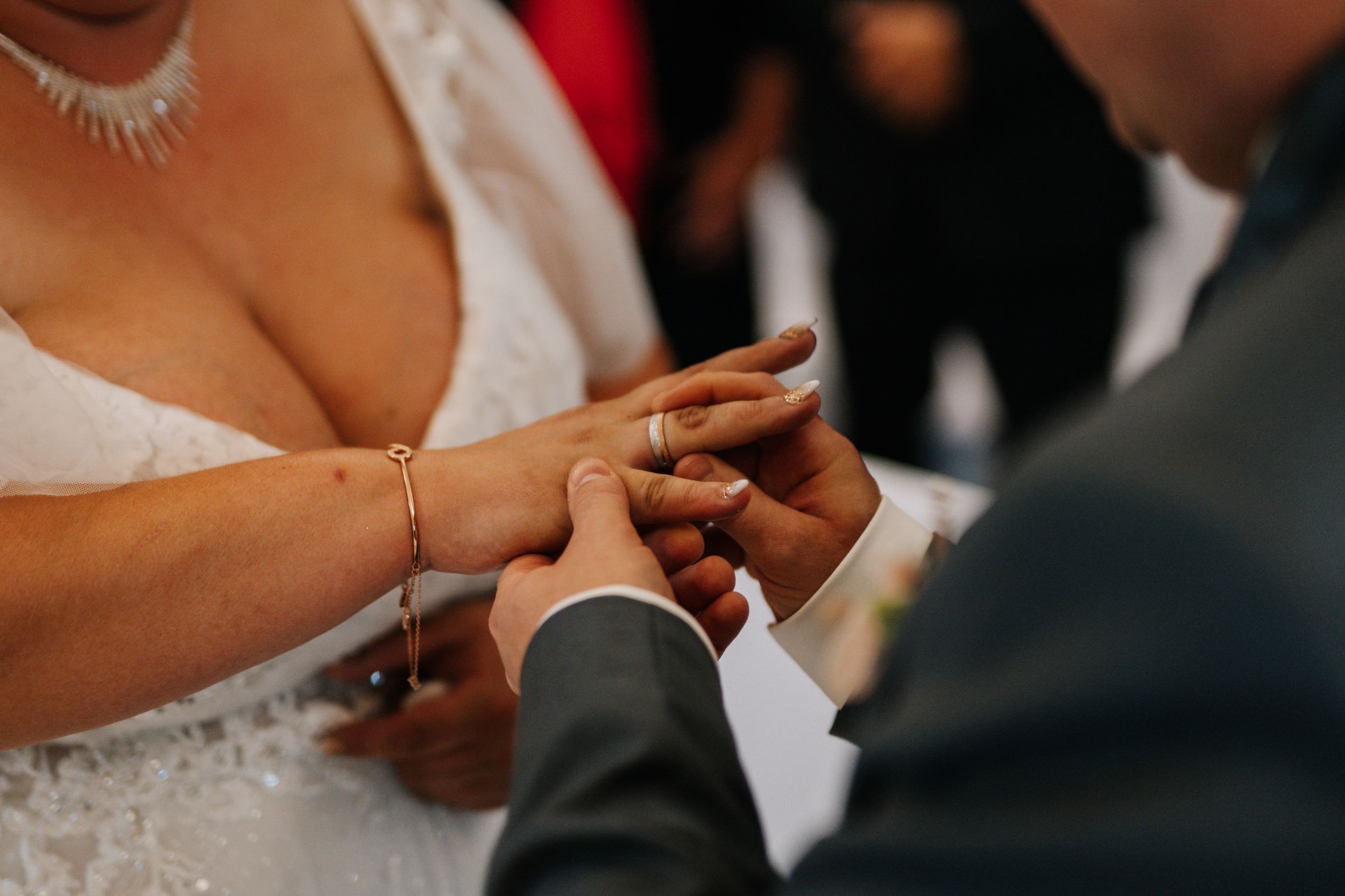 Close up shot of ring exchange during wedding ceremony.