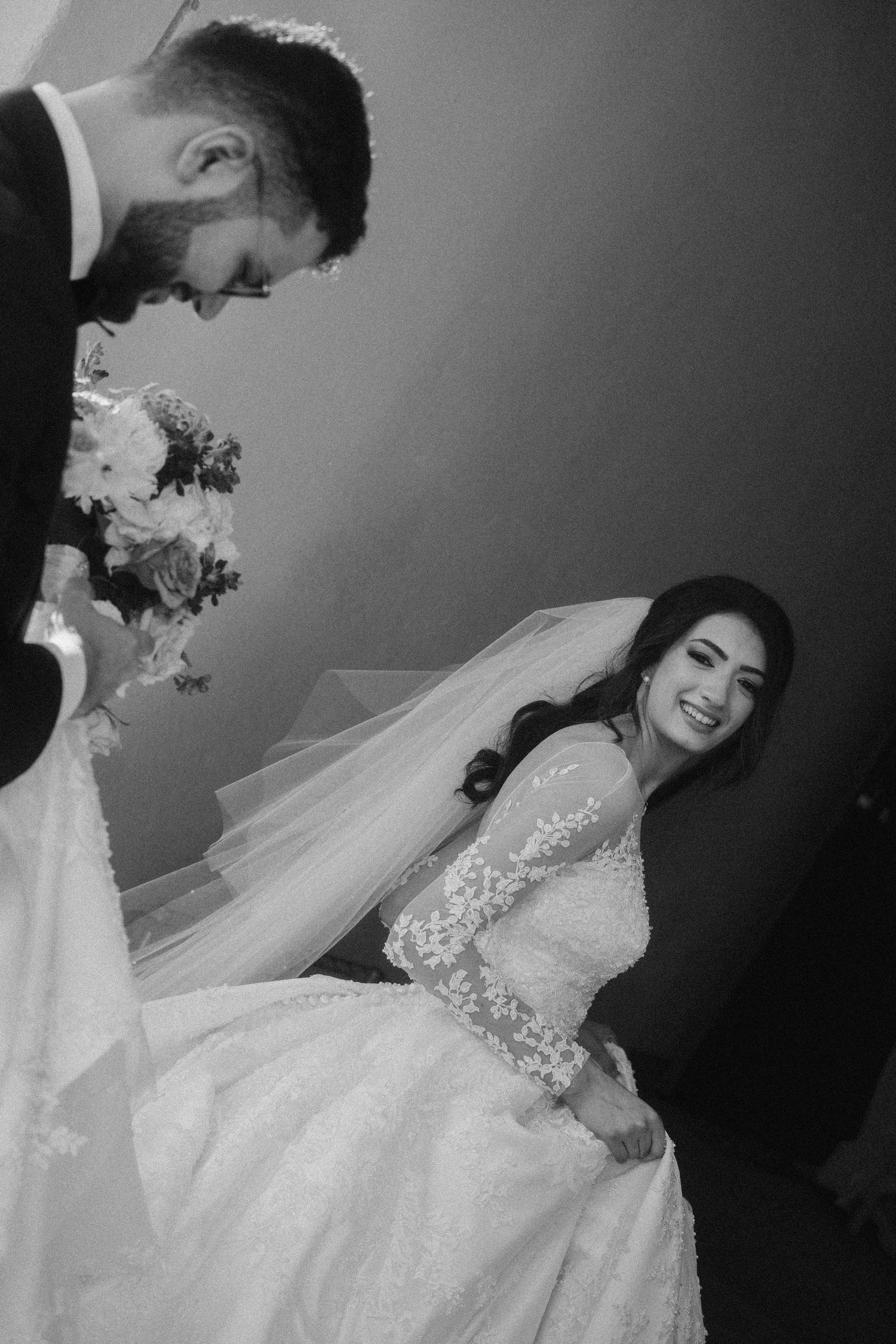 A black and white wedding portrait capturing a romantic moment between newlyweds.