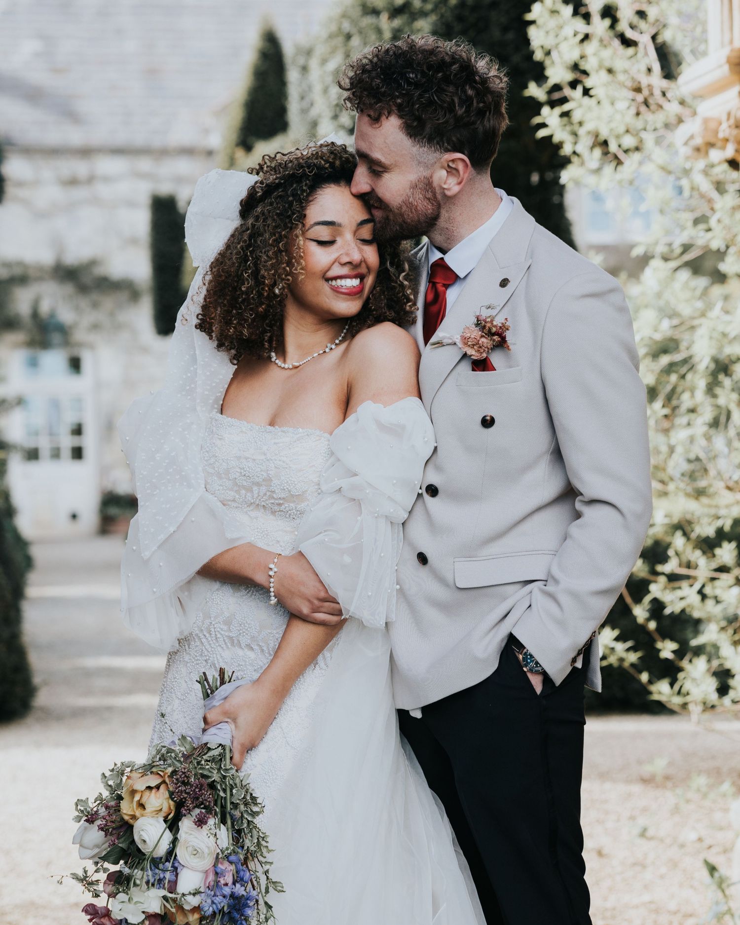 Wedding couple shares romantic moment as guests shower them with flower petals during outdoor ceremony celebration Winchester