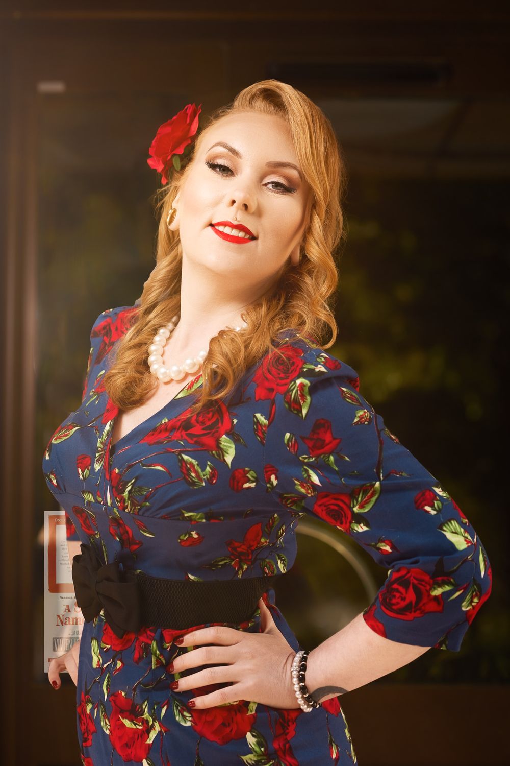 Classic portrait featuring floral dress with red roses and vintage inspired hair and makeup.
