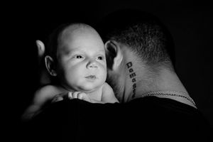 A black and white side profile portrait showing a peaceful moment with an alert baby.