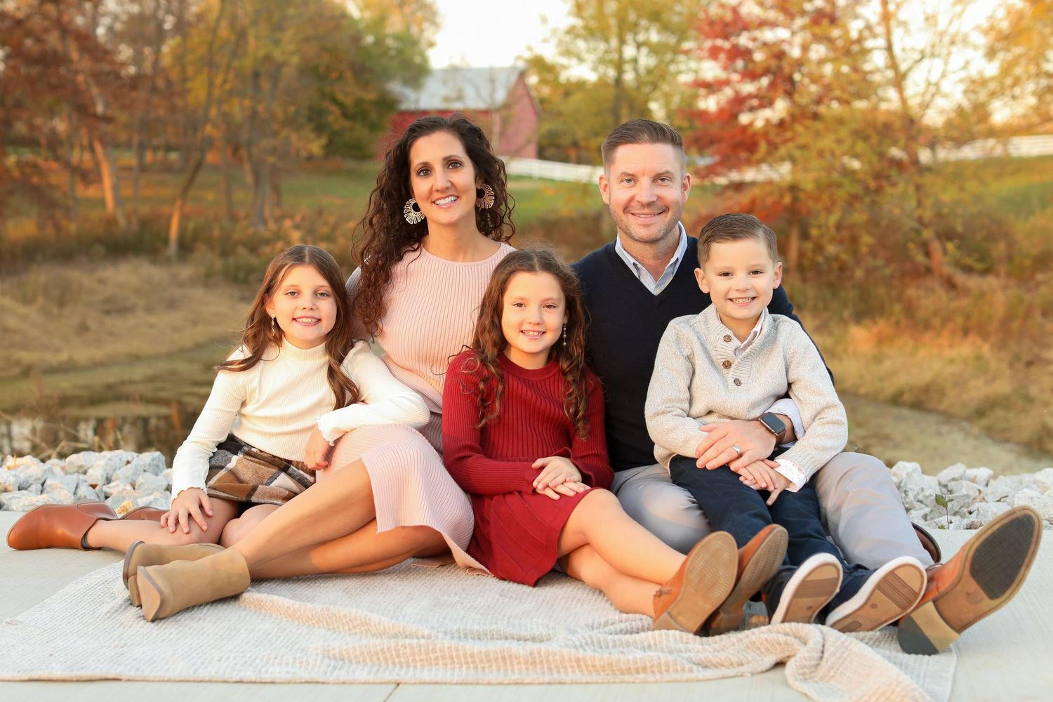 Family portrait session at sunset with autumn colors in the background.