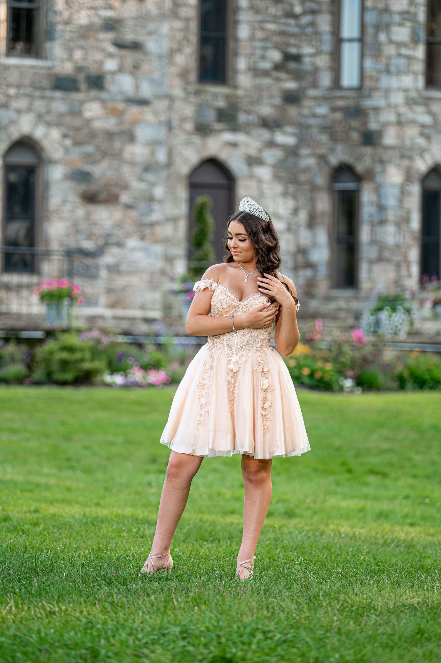 Playful outdoor photo session in peach dress near historic stone building.