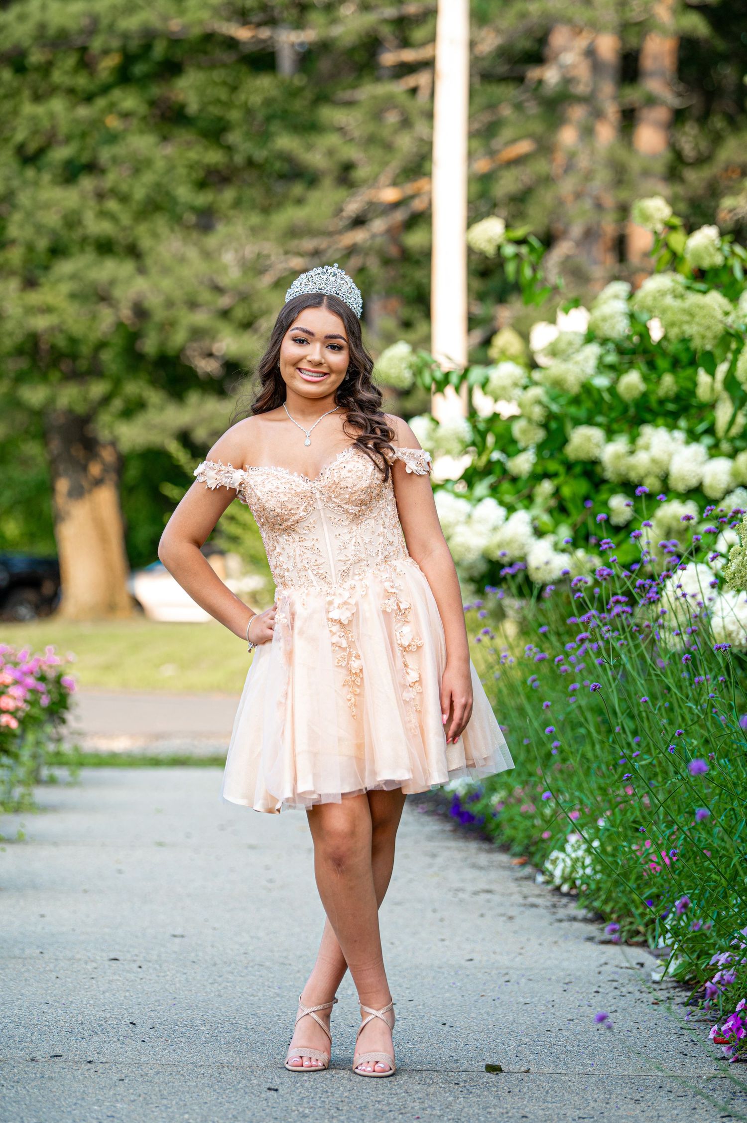 Garden photoshoot with peach dress amid blooming lavender and white flowers.