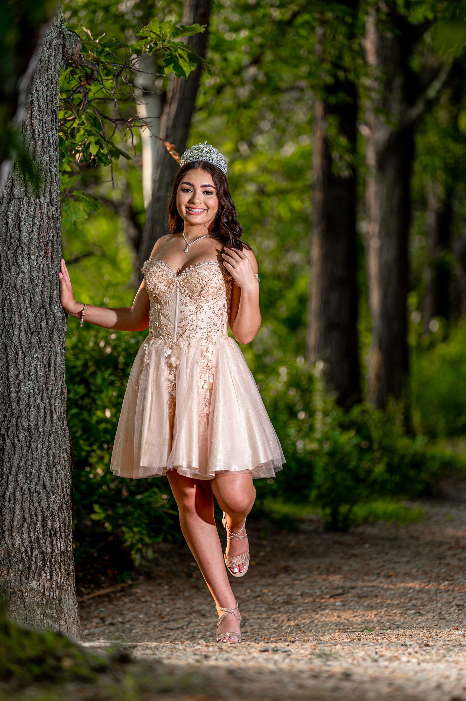 Whimsical forest photoshoot featuring light pink dress and natural woodland backdrop.