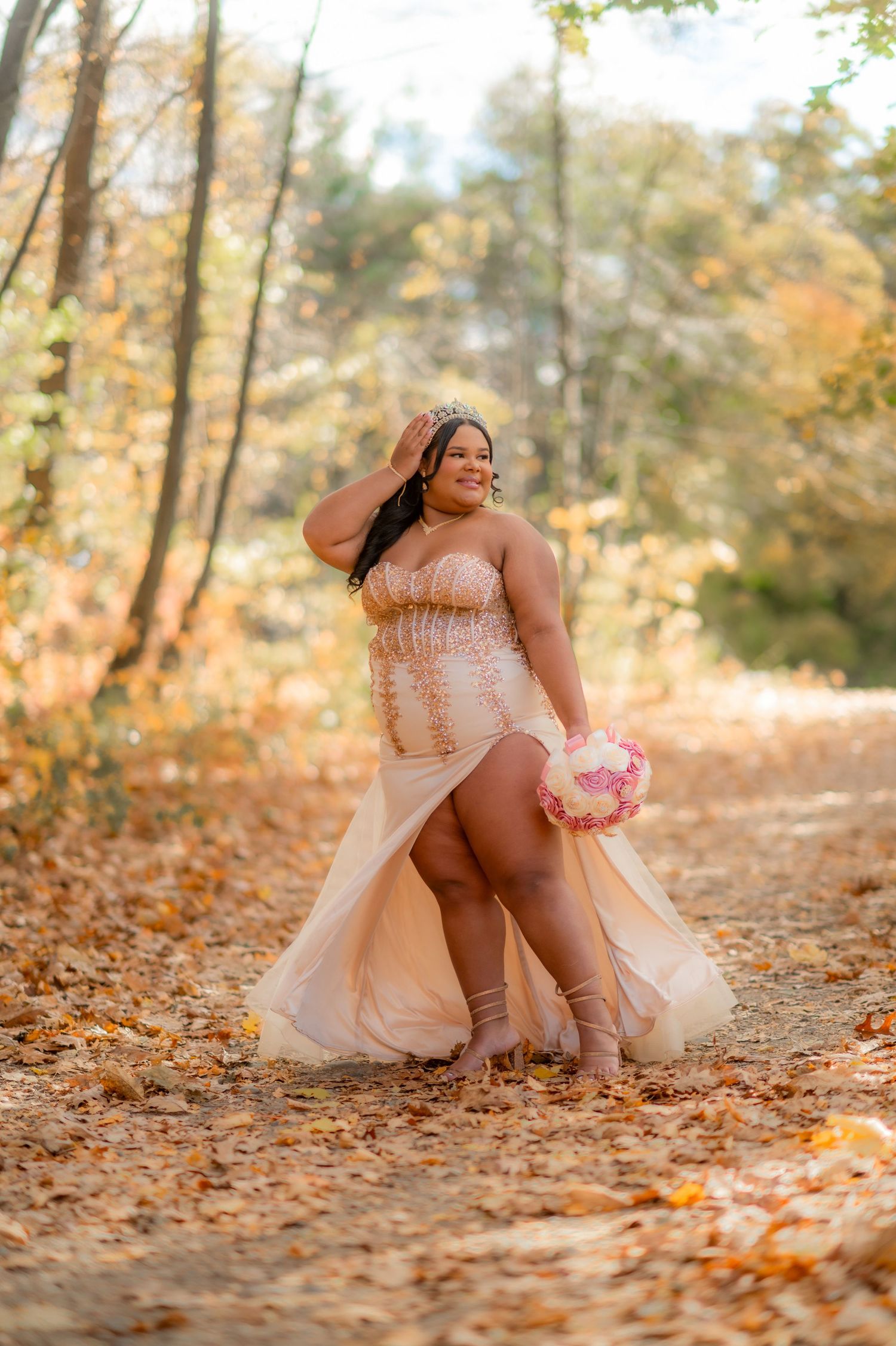 Dreamy outdoor portrait with pink dress and fallen leaves creating a whimsical autumn scene.
