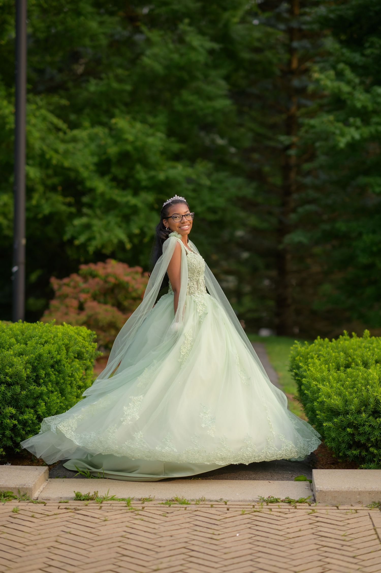 Stunning mint green wedding gown with dramatic train photographed in garden setting.