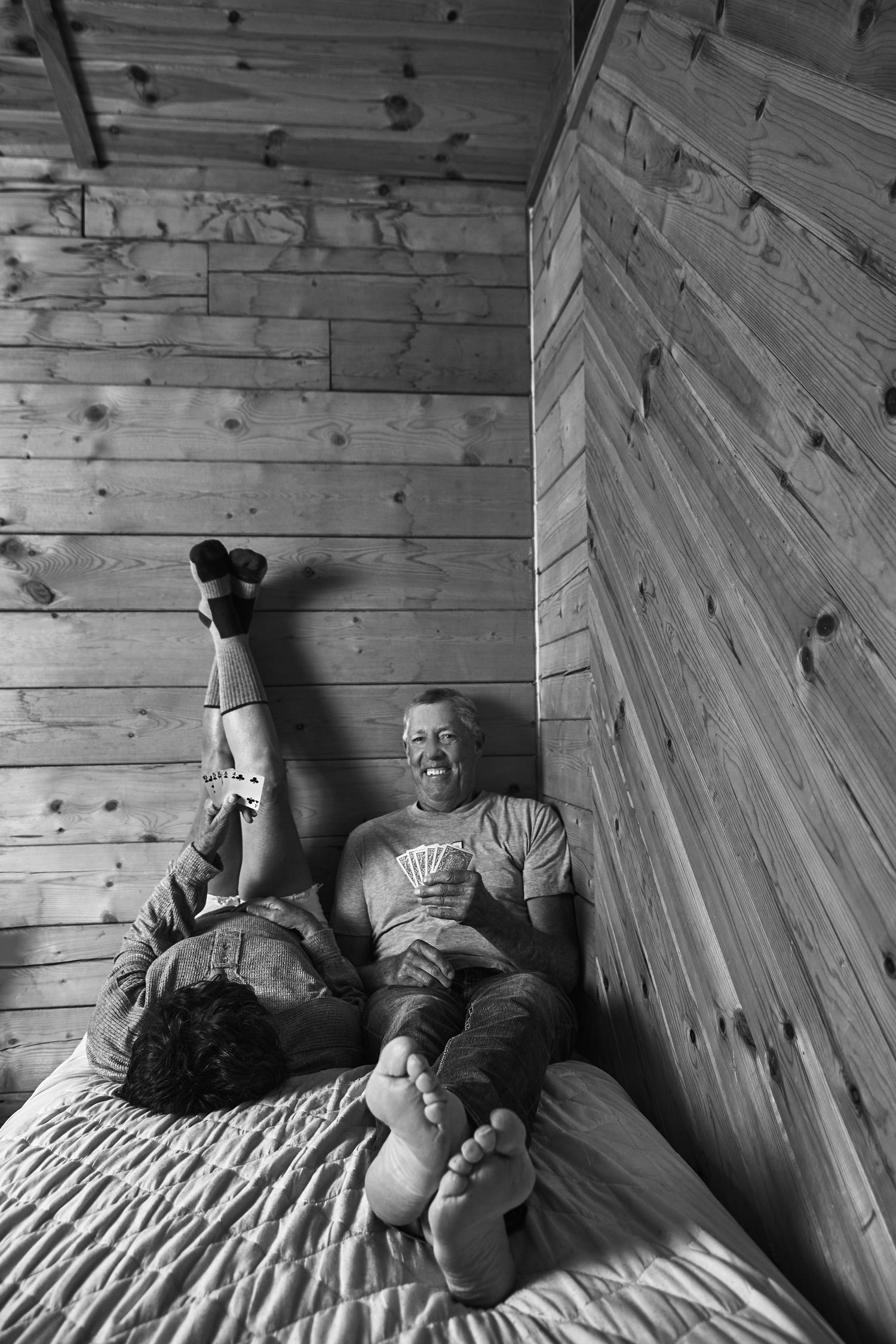 Series of artistic black and white photos showing relaxed poses against wooden wall panels.