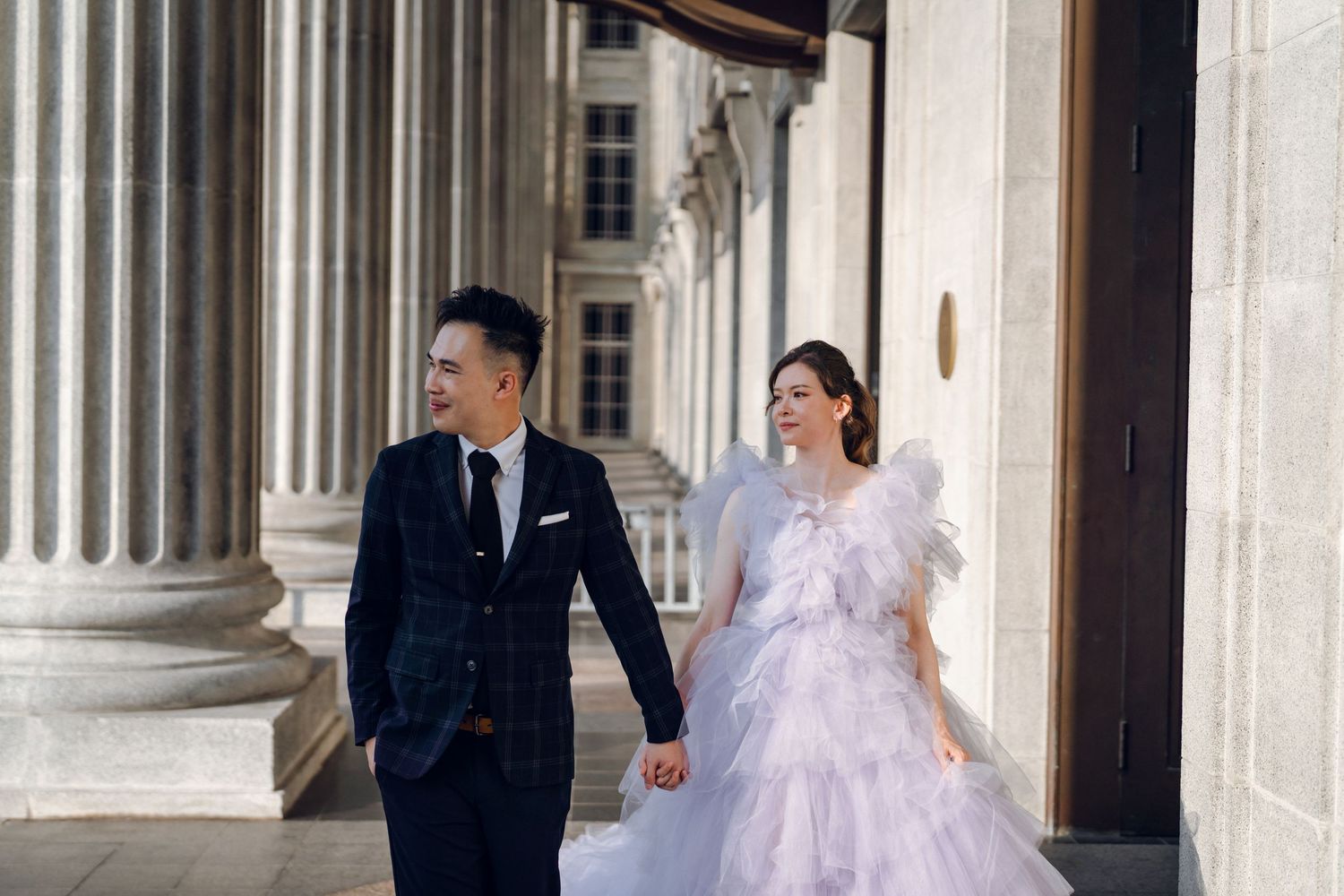A romantic moment captured between stone columns with a lavender tulle gown adding dramatic flair.