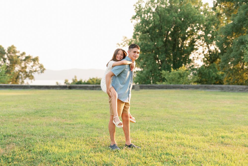 A playful piggyback ride moment captured in a sunny field.