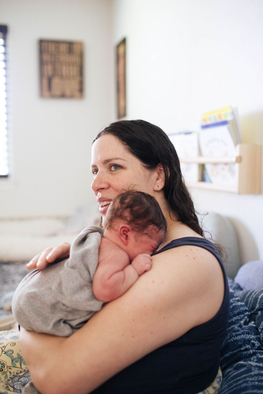 Everett WA fresh 48 photo shoot: At home with a mother holding her newborn baby in bed in Everett WA