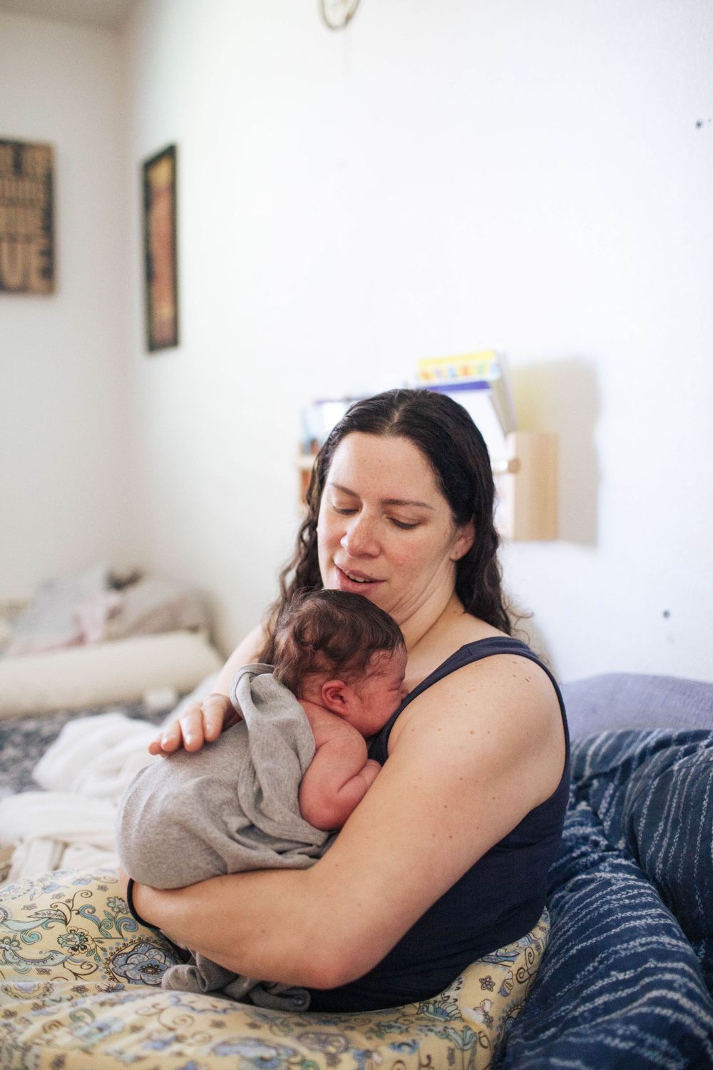 Everett WA fresh 48 photo shoot: At home with a mother holding her newborn baby in bed in Everett WA