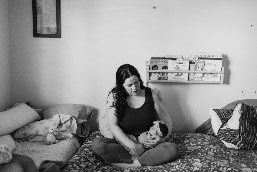 Everett WA fresh 48 photo shoot: At home with a mother holding her newborn baby in bed in Everett WA