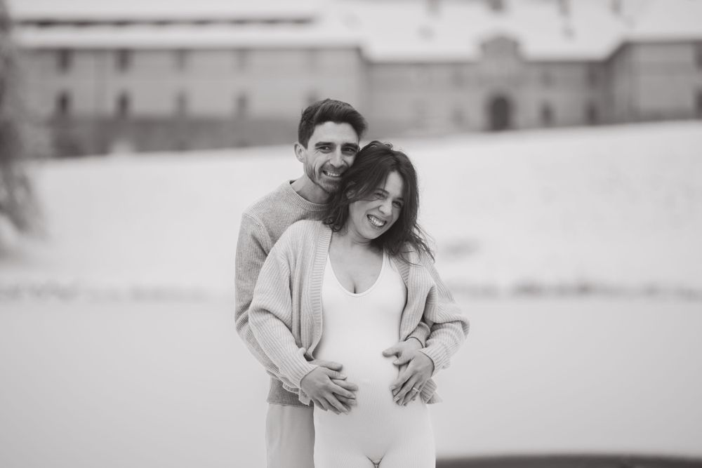 Black and white portrait of a couple sharing an intimate embrace in a winter setting.