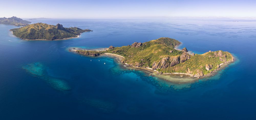 Panoramic aerial view of pristine islands surrounded by crystal clear turquoise waters.