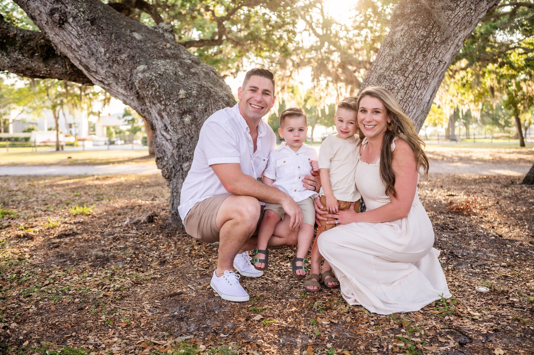 Family photoshoot session with two children sitting together park sunset trees Palm Bay Cocoa Beach Vero Florida Brevard County