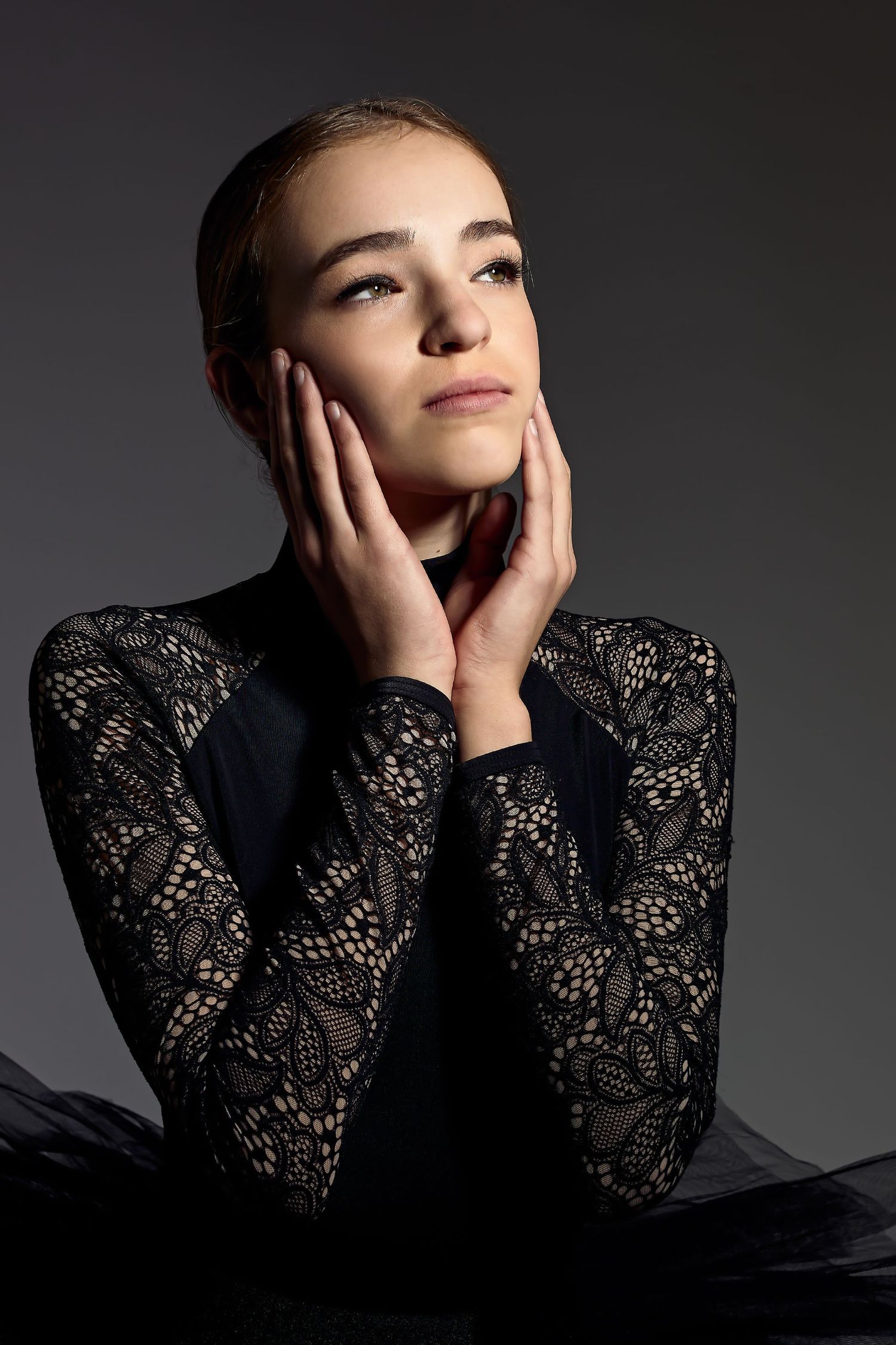 Dramatic studio portraits featuring black lace sleeves against dark background.