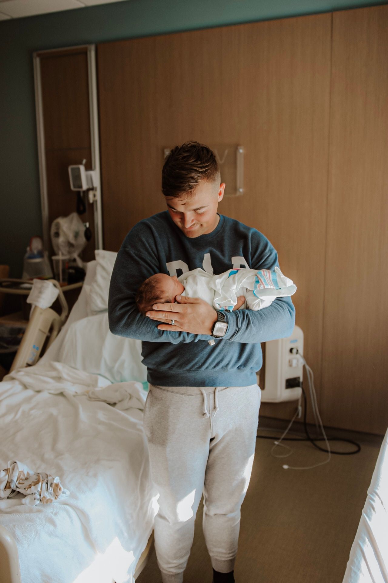 Intimate hospital room moments between parents and newborn baby.