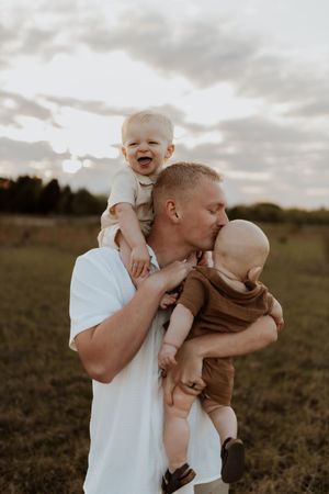 Playful family interaction captured during outdoor photo session at sunset.