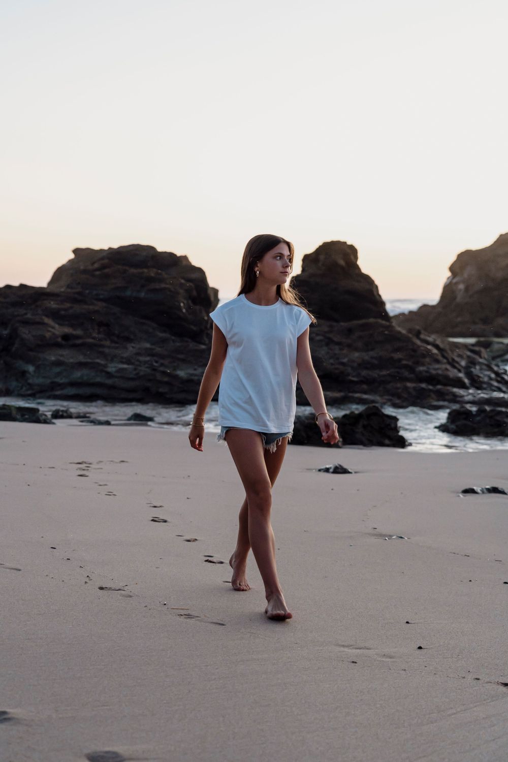 portrait  lifestyle sur la plage, jeune femme marchant sur le sable au couché de soleil.