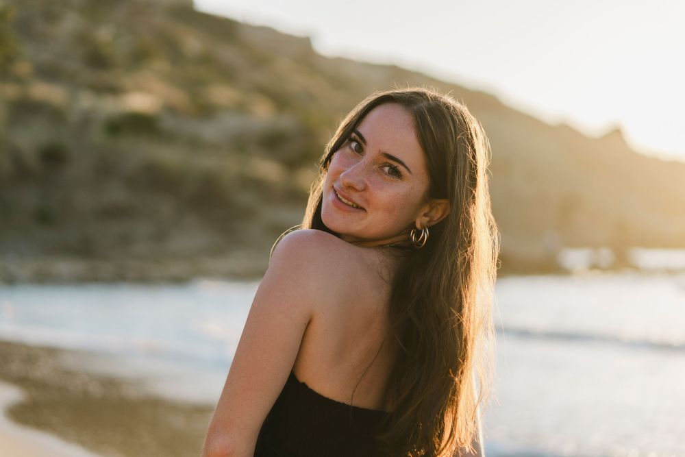 portrait  lifestyle en extérieur d'une jeune femme à la plage, golden hour