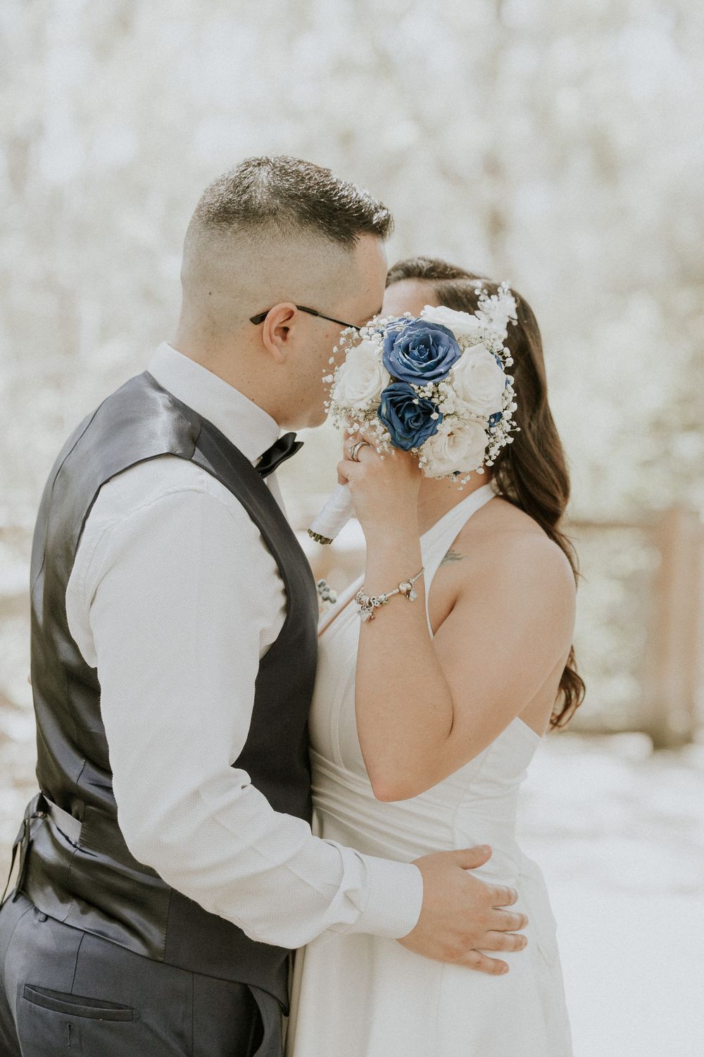 Wedding couple sharing intimate moment with decorative blue floral headpiece.