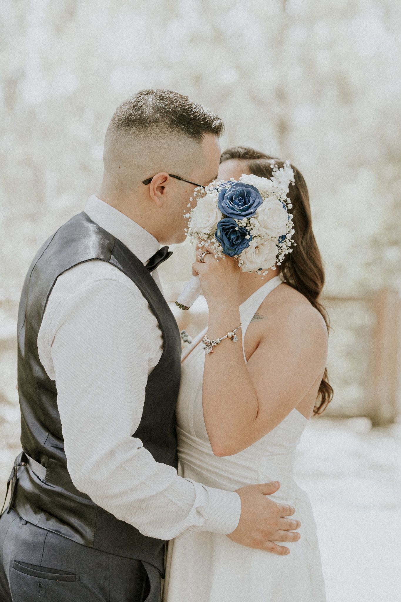 Wedding couple sharing intimate moment with decorative blue floral headpiece.