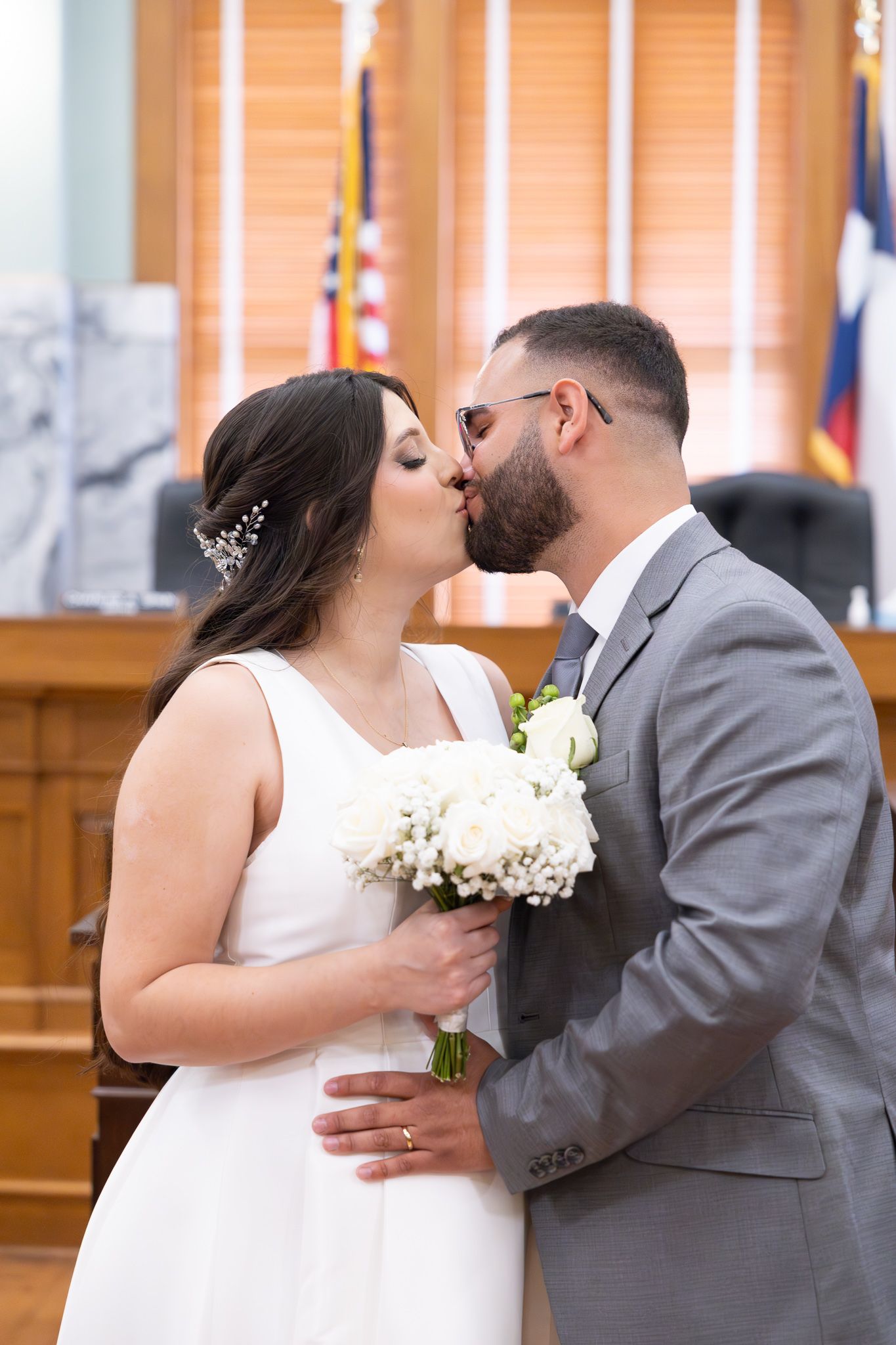 Intimate courthouse wedding ceremony with couple sharing first kiss.