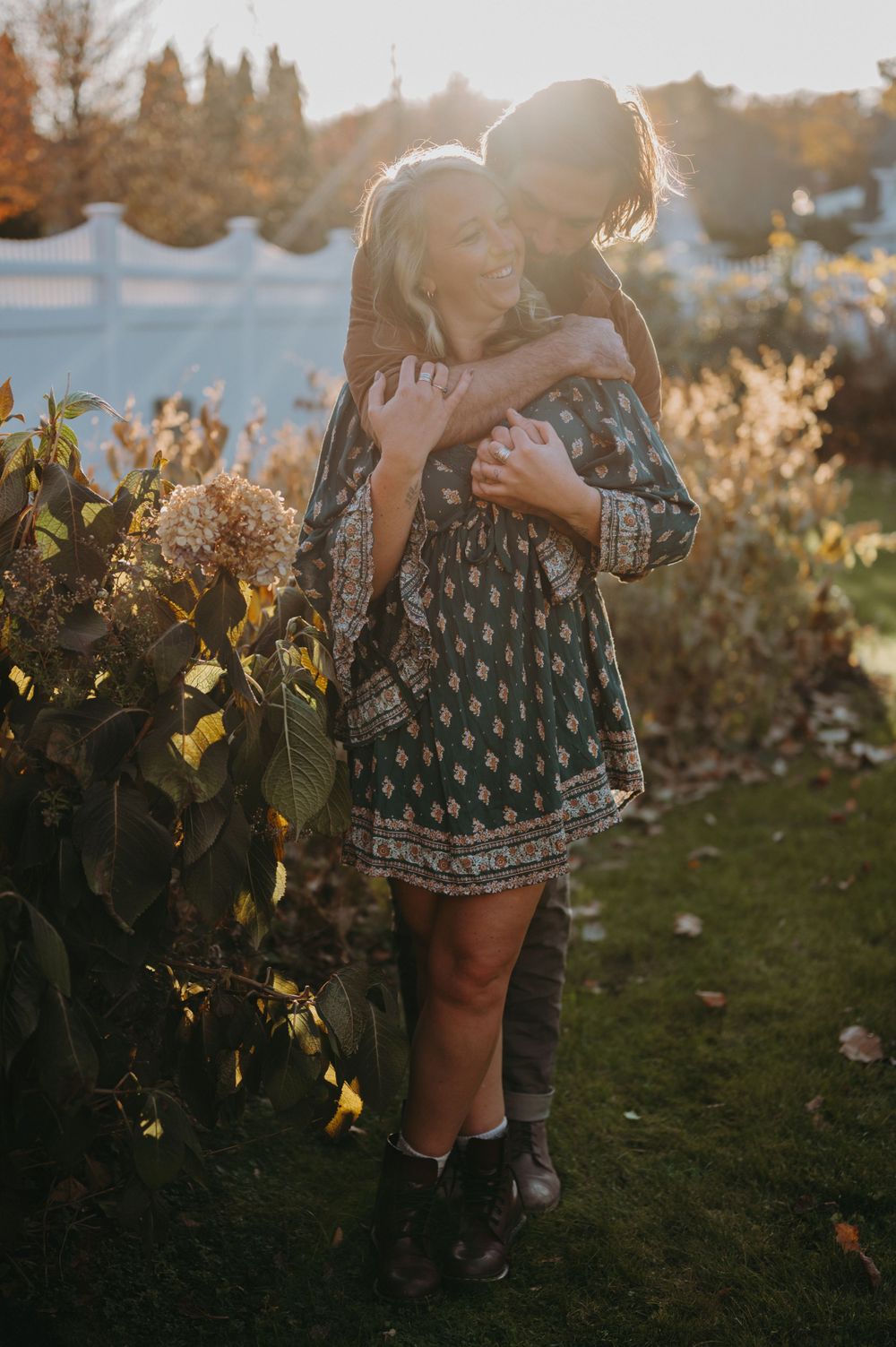A tender embrace captured in golden sunlight among autumn foliage.