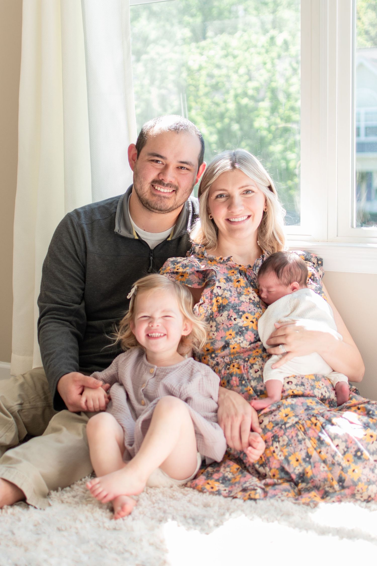In a sun-filled room, the new family is smiling as they have welcomed the newest member of their family.