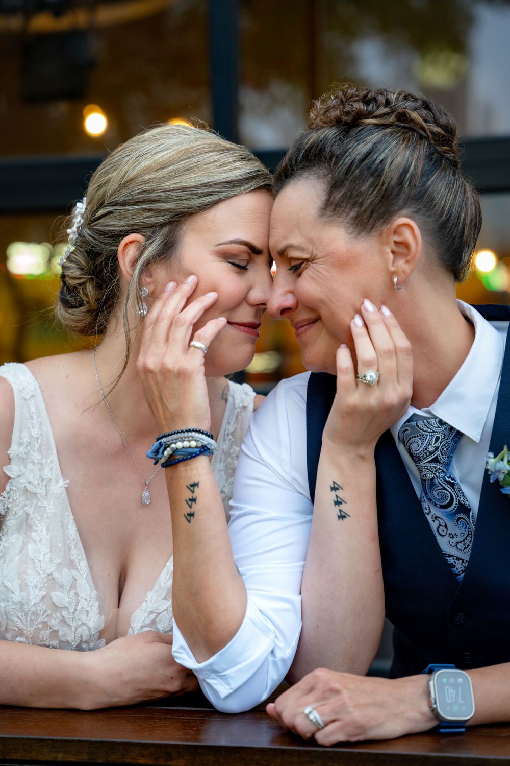 tender moments between a couple in bridal attire against a blurred outdoor setting.