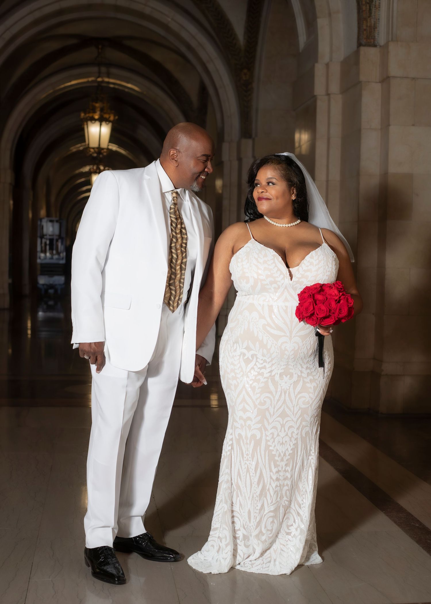 Photo of a wedding couple standing in a hallway.